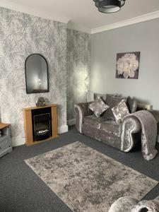 a living room with a couch and a mirror at hewitt place in Crewe