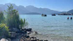 a body of water with boats and people in the water at Le Chalet de la Plage in Sévrier