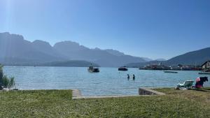 a view of a lake with people in the water at Le Chalet de la Plage in Sévrier