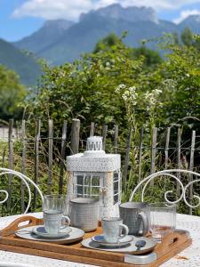 a table with plates and cups and a lantern on it at Le Chalet de la Plage in Sévrier