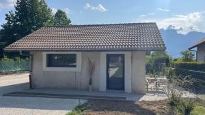 a small house with a door and a table at Le Chalet de la Plage in Sévrier