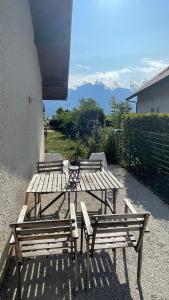 three wooden picnic tables sitting outside of a building at Le Chalet de la Plage in Sévrier
