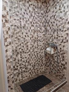 bagno con doccia e parete piastrellata di Elaėa Boutique Apartments a Pireo