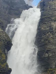 a waterfall on the side of a mountain at Trivelig hus sentralt på Storslett in Storslett