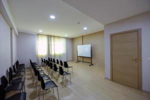 einen Konferenzraum mit Stühlen und einem weißen Bildschirm in der Unterkunft Sport Plaza Hotel & Apartments in Baku
