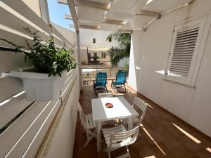 Elle comprend un petit balcon avec une table et des chaises blanches. dans l'établissement Monolocale Mulino, à Favignana