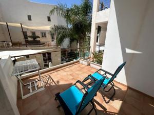 une paire de chaises et une table sur un balcon dans l'établissement Monolocale Mulino, à Favignana