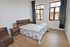 ein Schlafzimmer mit einem Bett und einem Sofa sowie zwei Fenstern in der Unterkunft Feine Wohnung mitten im Zentrum in Kusadası