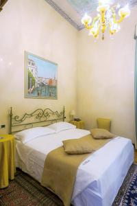 a bedroom with two beds and a chandelier at Villa Ducale Hotel & Ristorante in Dolo