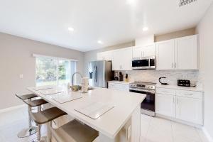 a kitchen with white cabinets and a white counter top at The Port of Paradise in Port Orange