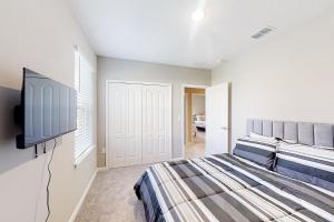 a bedroom with a bed and a flat screen tv at The Port of Paradise in Port Orange