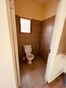 a bathroom with a toilet and a window at Lake Jipe Eco Lodge in Tsavo West National Park