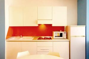 cocina con armarios blancos y microondas blanco en Residence Adriatico, en Gabicce Mare