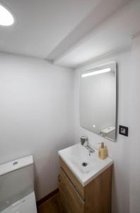 uma casa de banho branca com um lavatório e um espelho em El Merendero em Ateca