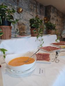 a bowl of soup on a table with meat at Hotel Palacio de la Magdalena in Soto del Barco