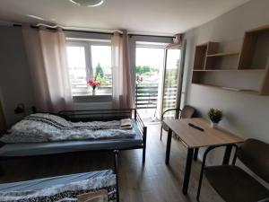 Habitación con cama, mesa y ventana en Tanie Noclegi, kwatery, pokoje do wynajęcia , TARGI KIELCE en Kielce
