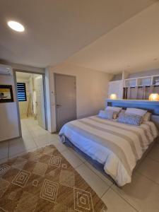 1 dormitorio con 1 cama grande y cabecero azul en Maryse’ House, en Les Avirons