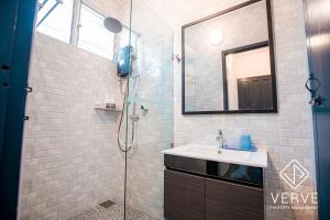 een badkamer met een douche, een wastafel en een spiegel bij Ipoh Garden East 3R2B 10PAX by Verve in Ipoh