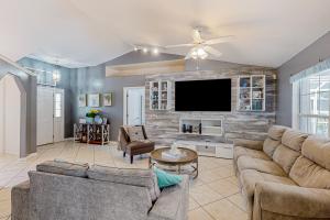 a living room with couches and a flat screen tv at Sunkissed in Kissimmee in Kissimmee