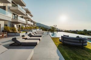 a building with a row of couches next to a pool at Toska Tower in Chrysi Ammoudia