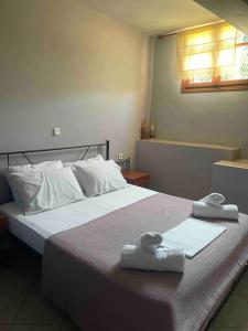 a bedroom with a large bed with towels on it at Alice Apartment in Agia Effimia