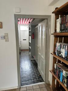 un couloir avec des étagères et une porte ouverte dans l'établissement Sesimbra Domburg, à Domburg