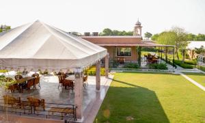 曼达瓦Aangan Resort的庭院内带桌椅的白色帐篷