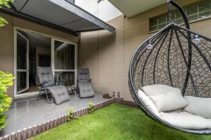 a hanging porch swing with chairs and grass at Cozy Apartment Karpia 17 with Terrace & PARKING in Poznań by Renters in Poznań