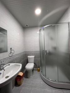 een badkamer met een douche, een toilet en een wastafel bij Almaz Hotel Uzbekistan in Tasjkent