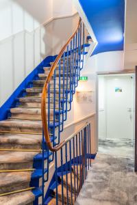 un escalier avec des balustrades bleues et un plafond bleu dans l'établissement La Finca Hôtel & Spa, à Paris