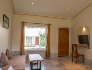 曼达瓦Aangan Resort的客厅设有窗户和桌子