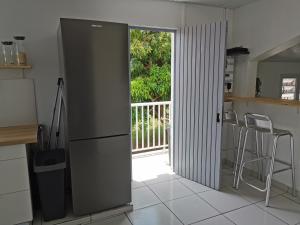 a kitchen with a refrigerator and a door to a balcony at Résidence La Cafeiere in Saint-Claude