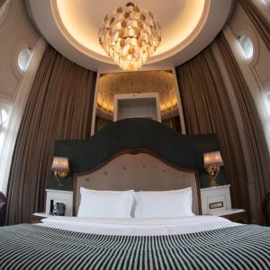 Un dormitorio con una cama grande y una lámpara de araña. en Orientbank Hotel Istanbul, Autograph Collection, en Estambul