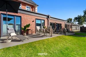 d'une cour avec des chaises et des tables. dans l'établissement Ferienwohnung Abenddämmerung, App 7 Emmelsbüll, à Emmelsbüll-Horsbüll