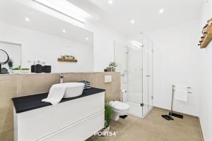 une salle de bain blanche avec lavabo et douche dans l'établissement Ferienwohnung Abenddämmerung, App 7 Emmelsbüll, à Emmelsbüll-Horsbüll 15 autres photos