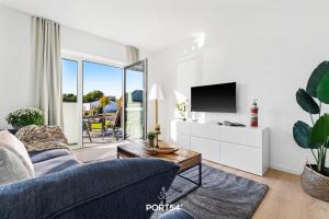 un salon avec un canapé et une télévision dans l'établissement Ferienwohnung Abenddämmerung, App 7 Emmelsbüll, à Emmelsbüll-Horsbüll