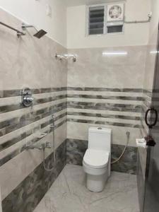 a bathroom with a toilet and a shower at Variyar Service Apartments Unit A Ground Floor in Vellore +8 photos