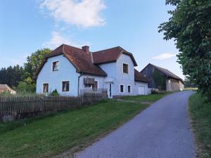 une maison blanche avec une clôture à côté d'une route dans l'établissement Landhaus auf der Alm, 