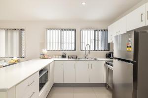 a kitchen with white cabinets and a stainless steel refrigerator at 2 Bedroom! Great Location & Walk to Train in Brisbane