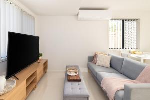 a living room with a couch and a tv at 2 Bedroom! Great Location & Walk to Train in Brisbane