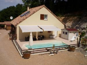 una pequeña casa con piscina frente a ella en Gîte les Roziers, en Montmurat