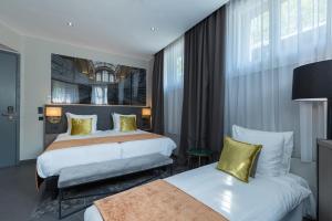 una camera d'albergo con due letti con cuscini gialli di Leonardo Boutique Museumhotel ad Amsterdam