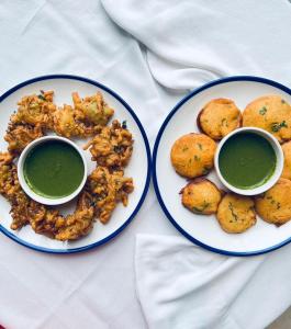 dwie talerze jedzenia z zielonym sosem i zanurzeniami w obiekcie Courtyard by Marriott Surat w mieście Surat