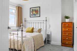 a bedroom with a bed and a dresser at Stunning 4 bedroom home near cotswolds and Stratford upon avon in Tredington