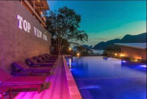 a swimming pool with purple lounge chairs next to a building at PP Midnight Hotel in Phi Phi Don