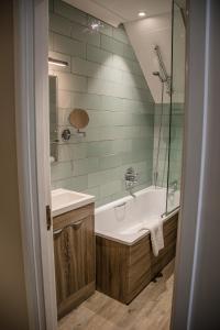 uma casa de banho com uma banheira, um lavatório e um chuveiro em The Lodge At Meyrick Park em Bournemouth