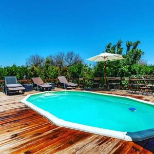 - Piscina con mesa y sombrilla en Masseria li Vecchi, en Squinzano