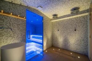 baño con ducha a ras de suelo con luces azules en La Finca Hôtel & Spa en París