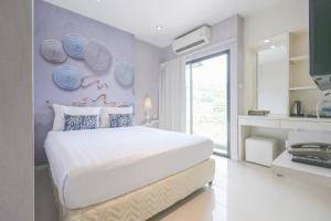 Un dormitorio con una cama con una pared con placas. en Sino Maison, en Patong Beach