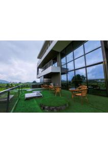 a building with a balcony with tables and chairs at Villa Le Camelia in Igatpuri